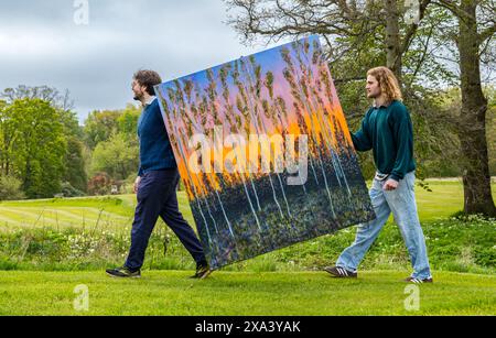 Künstler Joe trauert mit einem seiner großen farbenfrohen Gemälde bei der ersten Kunstausstellung im Colstoun House, East Lothian, Schottland, Großbritannien Stockfoto