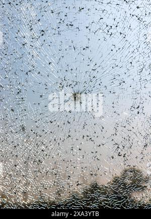 Gebrochene Windschutzscheibe eines Autos, Nahaufnahme als Hintergrund. Glasbruch mit Rissen. Stockfoto