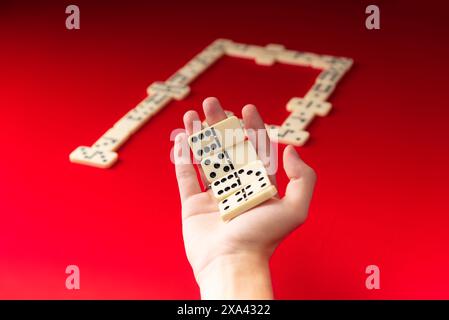 Domino-Spieler mit rechteckigen Acrylstücken. Brettspiel. Roter Hintergrund. Stockfoto