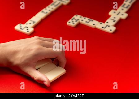 Domino-Spieler mit rechteckigen Acrylstücken. Brettspiel. Roter Hintergrund. Stockfoto