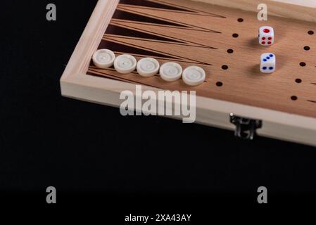 Traditionelles Backgammon-Spiel. Brett mit Backgammon Spielstücken auf schwarzem Hintergrund. Stockfoto