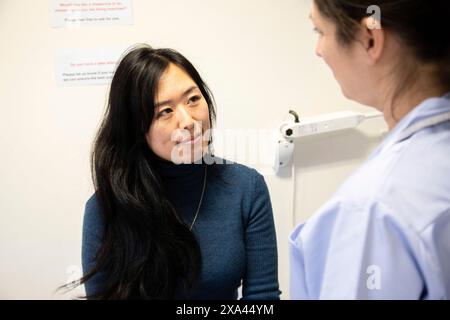 Krankenschwester im Gespräch mit einem Patienten in einer Arztpraxis Stockfoto