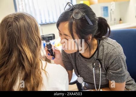 Arzt, der eine Ohruntersuchung an einem Patienten durchführt Stockfoto