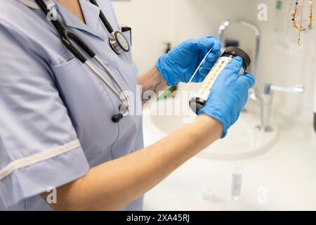 Hände in Handschuhe, die ein Testergebnis handhaben Stockfoto