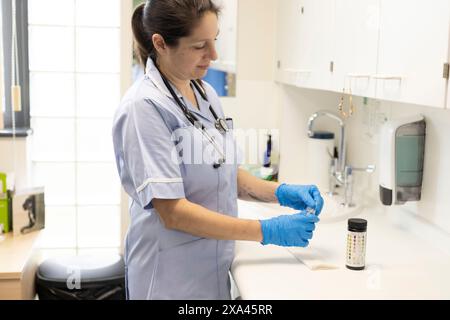 Hände in Handschuhe, die ein Testergebnis handhaben Stockfoto