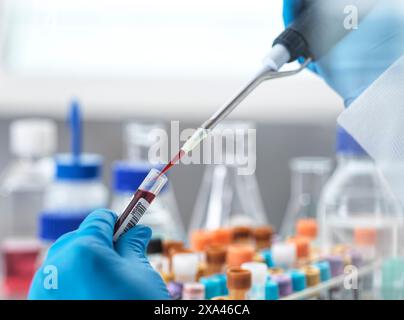 Labortechniker pipettieren einer Blutprobe Stockfoto