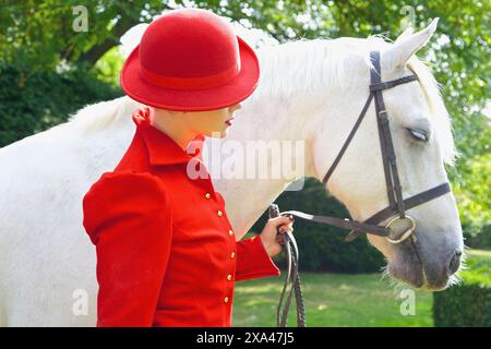 Frau in rot Reit Outfit mit Pferd Stockfoto