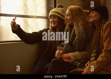 Teenager-Mädchen sitzen auf Zug Selfie Stockfoto