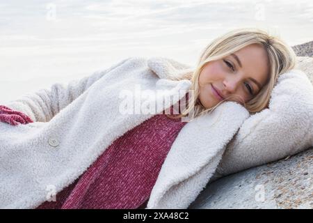 Junge Frau im Winter am Strand Stockfoto