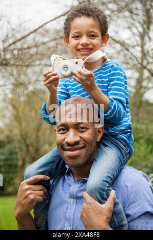 Vater trägt Sohn auf den Schultern im Freien Stockfoto