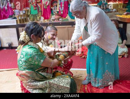 Bei einem Valaikappu-Service ist es üblich, Armbänder an das Handgelenk der Mutter zu legen. Das Geräusch stimuliert die Sinne und Gehirnaktivität des Babys. Stockfoto