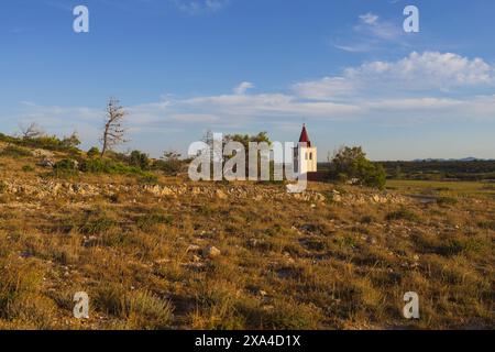 Foto einer kleinen weißen Kirche auf einsamen felsigen Land bei Sonnenuntergang in der Nähe von Vrsi in Dalmatien, Kroatien Stockfoto