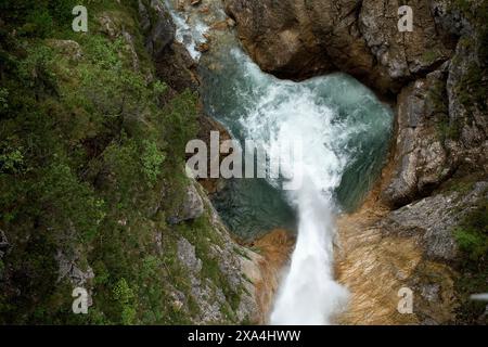 Ein Blick aus der Luft auf einen turbulenten Fluss, der durch eine enge felsige Schlucht mit üppigem Grün an den Seiten verläuft. Stockfoto