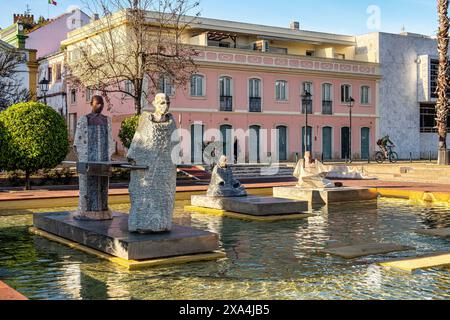 Praca Al Mutamid Platz mit Springbrunnen und modernen Skulpturen in Silves, Portugal. Statuen männlicher Steinmönche in einem Zierbecken in Praca Al-Mutami Stockfoto