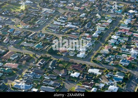 Ein Blick aus der Vogelperspektive auf eine Wohngegend mit zahlreichen Häusern, Straßen und Gartenanlagen unter klarem Himmel, Neuseeland Stockfoto