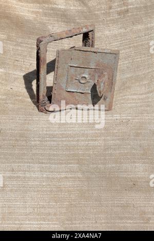 Alte gusseiserne Tür für den Herd. Es steht auf einem groben Tuch. Stockfoto