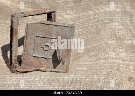 Alte gusseiserne Tür für den Herd. Es steht auf einem groben Tuch. Stockfoto