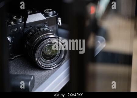 Nahaufnahme einer schwarzen Spiegelreflexkamera mit Objektiv auf einem Regal. Stockfoto