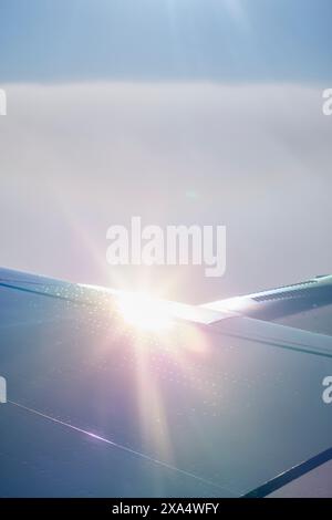 Sonnenlicht, das während des Fluges über einem Flugzeugflügel gegen einen klaren blauen Himmel leuchtet. Stockfoto