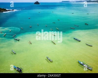 Traditionelle Boote im Outrigger-Stil in einem warmen, matschigen Ozean in Lombok, Indonesien Stockfoto