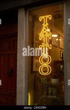 Ein Neon-Tattoo-Schild mit grünem Planta im Hintergrund Stockfoto