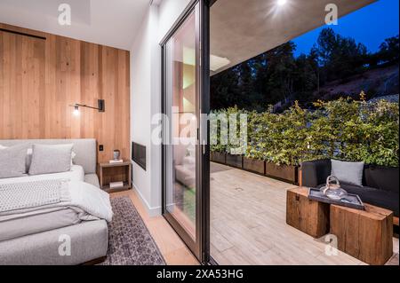 Modernes Hauptschlafzimmer mit Glastüren zum Balkon und Garten Stockfoto