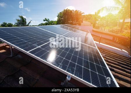 Installation von Solarpaneelen auf Tondach in blauem Himmel mit Sonnenhintergrund Stockfoto