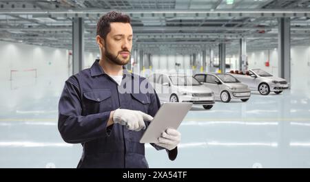 Automechaniker mit einem digitalen Tablet in einer Autogarage Stockfoto