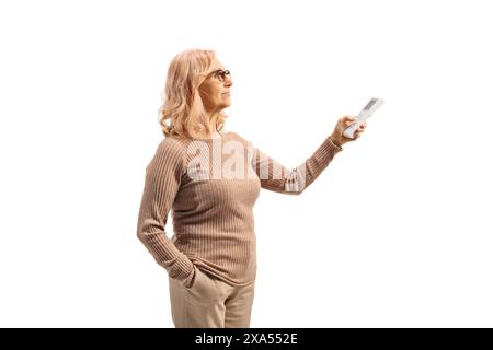 Frau mittleren Alters mit Fernbedienung für Klimaanlage isoliert auf weißem Hintergrund Stockfoto
