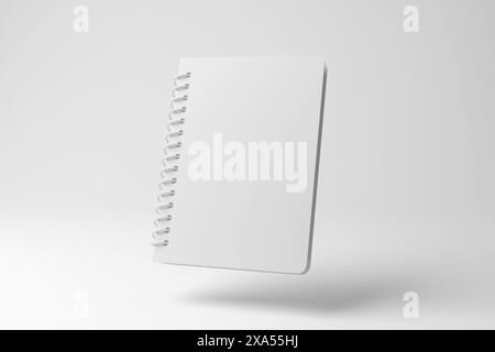 Weißes, spiralgefüttertes Notebook, das in der Luft auf weißem Hintergrund schwebt, in Monochrom und Minimalismus. Bildung, Büromaterial und Notizen Stockfoto
