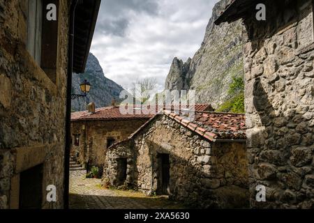 Ein kleines Dorf mit Steinhäusern und einem Steinweg in Nordspanien. Die Häuser haben eine rustikale Atmosphäre. Der Himmel ist bewölkt und die Berge im Ba Stockfoto