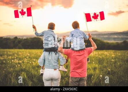 Niedliche, süße Familie mit kanadischer Flagge auf der Schulter Stockfoto