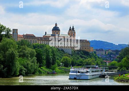 Melk - Österreich, 2024. Melk Abbey auf dem Hügel mit Flussschiff, das auf der Donau verankert ist. Eine sehr beliebte Art, alle Sehenswürdigkeiten entlang des Dan zu sehen Stockfoto