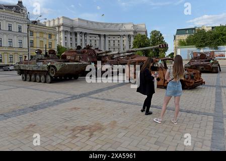 Menschen, die die Überreste zerstörter und gefangengenommener russischer Panzer und Fahrzeuge auf dem Maiden Square in Kiew, Ukraine, im Mai 2024 betrachten Stockfoto