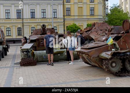 Menschen, die die Überreste zerstörter und gefangengenommener russischer Panzer und Fahrzeuge auf dem Maiden Square in Kiew, Ukraine, im Mai 2024 betrachten Stockfoto