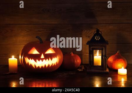 Halloween Kürbiskopf Jack Laterne mit brennenden Kerzen auf altem Holztisch. Halloween-Design mit Kürbissen. Stockfoto