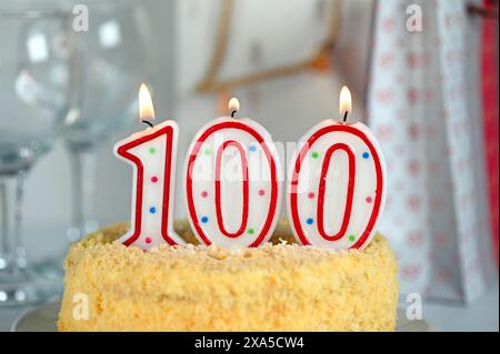 Festkuchen mit brennender Kerze Nummer 100 Stockfoto
