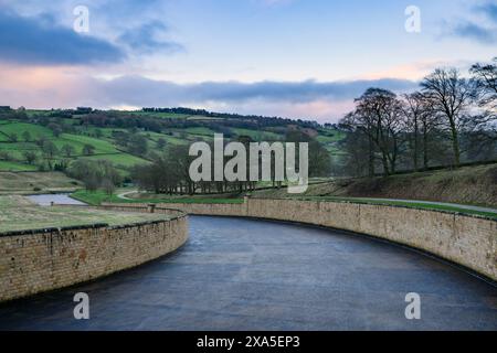 Wassersturzgefahr, sanfter Abstieg, Steinmauern, malerische Landschaft und Abendhimmel bei Sonnenuntergang - Swinsty Reservoir, England Großbritannien. Stockfoto