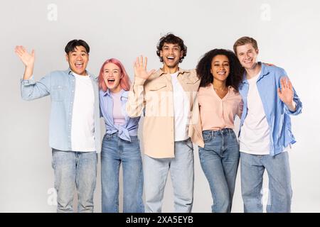 Verschiedene Gruppe glücklicher junger Erwachsener posiert vor weißem Hintergrund Stockfoto