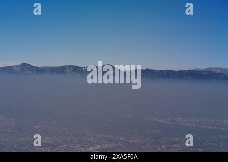 Aus der Vogelperspektive, Blick nach Norden, zeigt eine schwere Smogschicht über dem Gebiet von Glendale, Pasadena mit der Spitze der San Gabriel Mountains in der Ferne. Stockfoto
