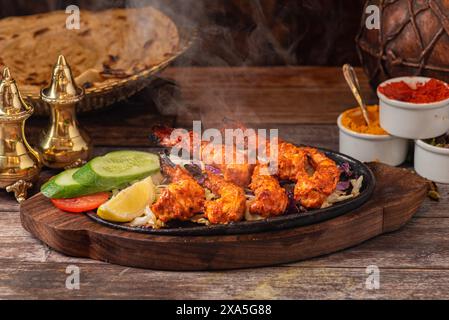Eine Platte mit Hühnerspießen auf einem Holzbrett Stockfoto