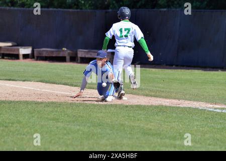 Illinois, USA. Frist Baseman erstreckt sich bis zum Shortstop, da der Baserunner während eines High School Baseballs sicher an der ersten Base ankommt Stockfoto