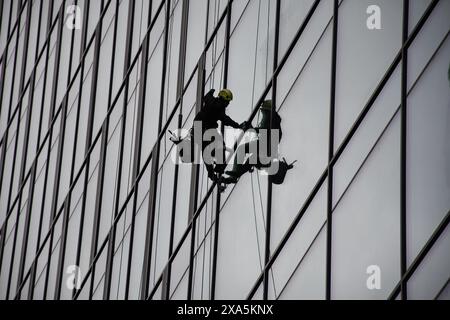 Ein Fensterputzer in der Luft, der Wolkenkratzerfenster in Polen reinigt Stockfoto