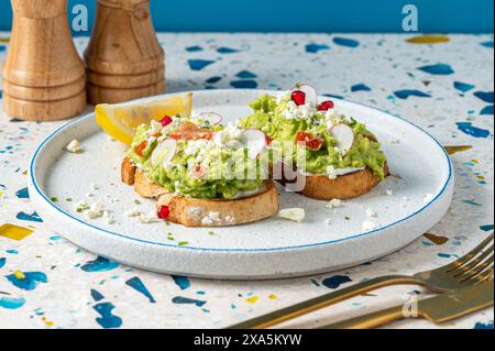 Zwei Avocadoscheiben auf Tellern mit Besteck, weißer Hintergrund Stockfoto