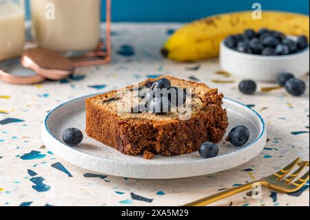 Eine Portion Bananenbrot mit frischen Blaubeeren auf einem Teller Stockfoto