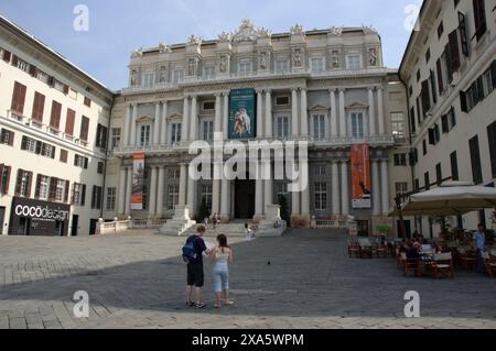 Junge Paare durchsuchen ihre Karte auf der Piazza Giacomo Matteotti vor dem Palazzo Ducal (Dogenpalast) in Genua, Italien Stockfoto