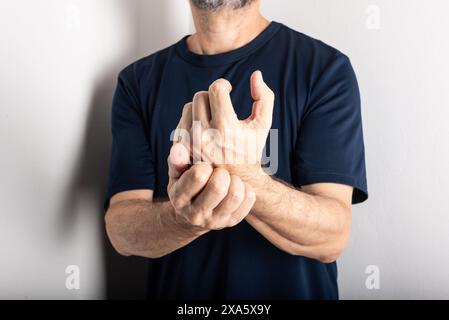 Mann mittleren Alters kratzt sich die Hand. Hautkrankheiten. Allergische Reaktion. Dermatologische Versorgung Stockfoto