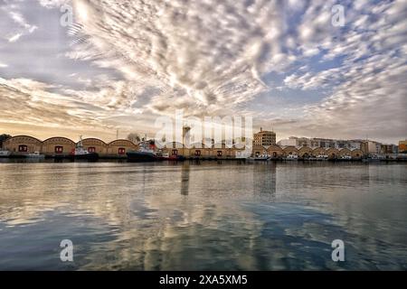 Boote in der Nähe des Piers auf dem Wasser bei Sonnenuntergang Stockfoto