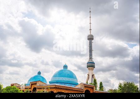 Fernsehturm und Kuppeln des Museums der Erinnerung an die Opfer der politischen Unterdrückung in Taschkent in Usbekistan vor dem Hintergrund des bewölkten Himmels im Frühjahr Stockfoto