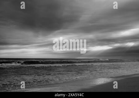 Ein malerischer Blick auf dunkle Wolken über dem Meer in Graustufen Stockfoto